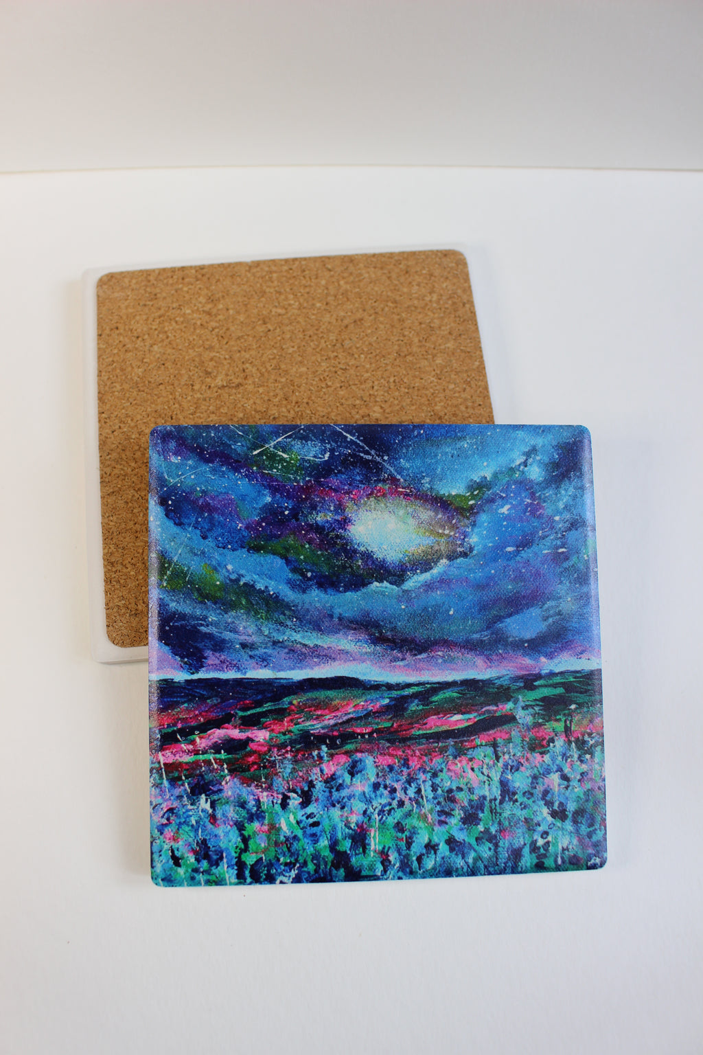10x10cm square ceramic coaster featuring vibrant, hand-painted landscape art with a protective cork backing.