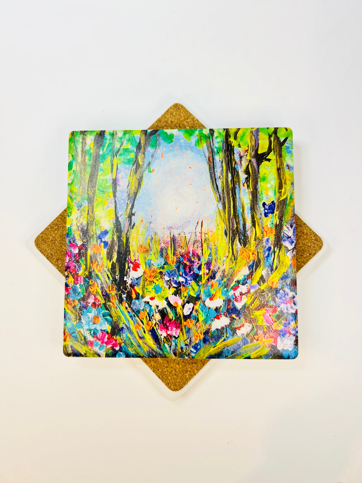 10x10cm square ceramic coaster featuring a colorful hand-painted forest flower art print with a protective cork backing.