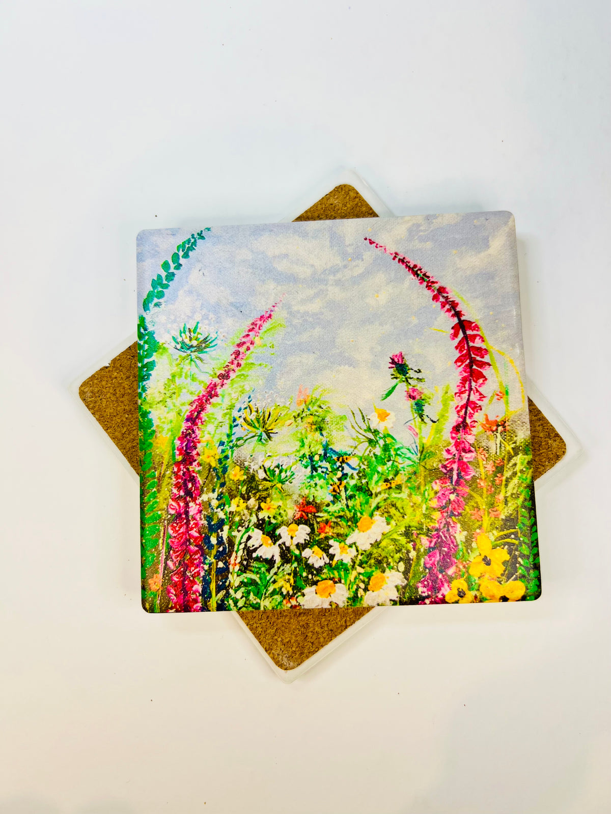 Square 10x10cm ceramic coaster with hand-painted wild flower art, featuring a protective cork backing on a white background.