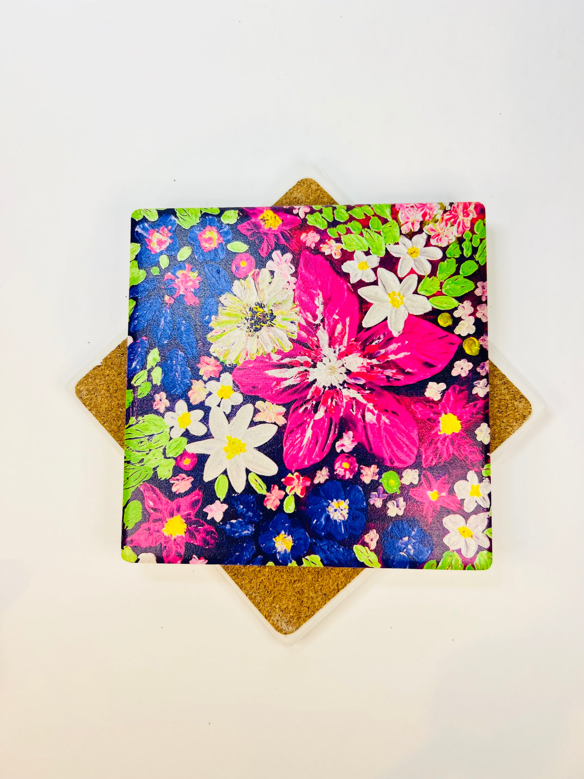 Square ceramic coaster with vibrant floral art print in pink, blue, and green