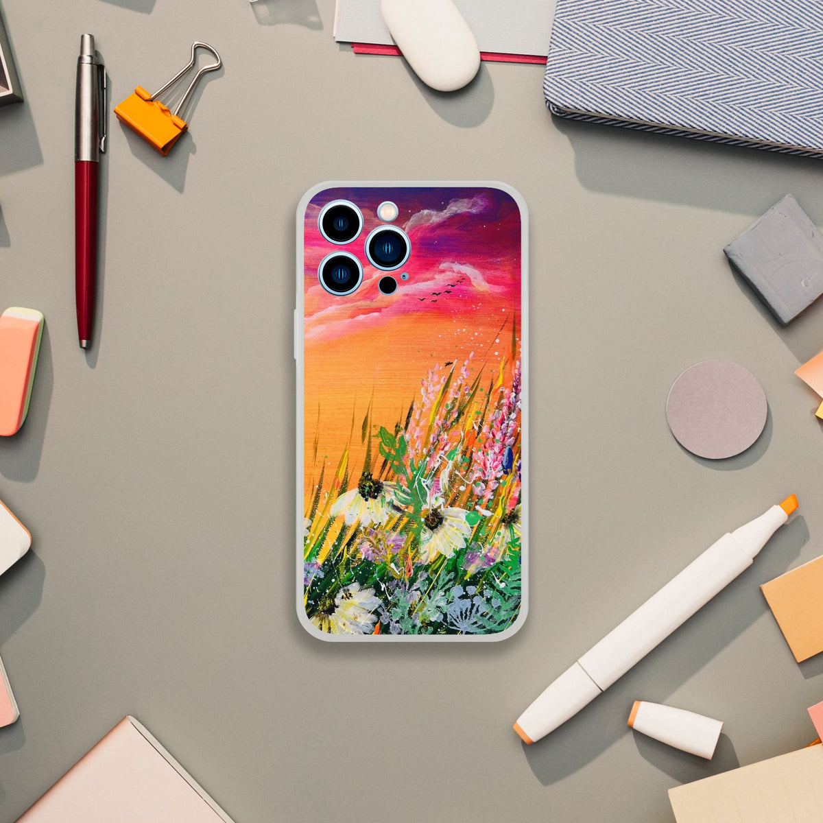 Flexible phone case featuring a vibrant sunset meadow painting with white flowers on a frosty transparent background.