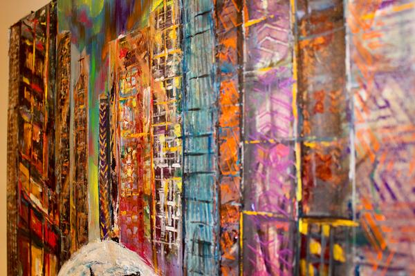 Abstract wall art close-up of vertical city panels in orange, blue, and purple hues