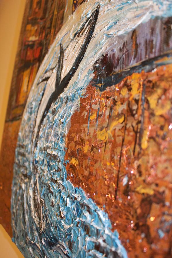 Close-up abstract wall art with white dolphin form and black fin over blue and orange texture