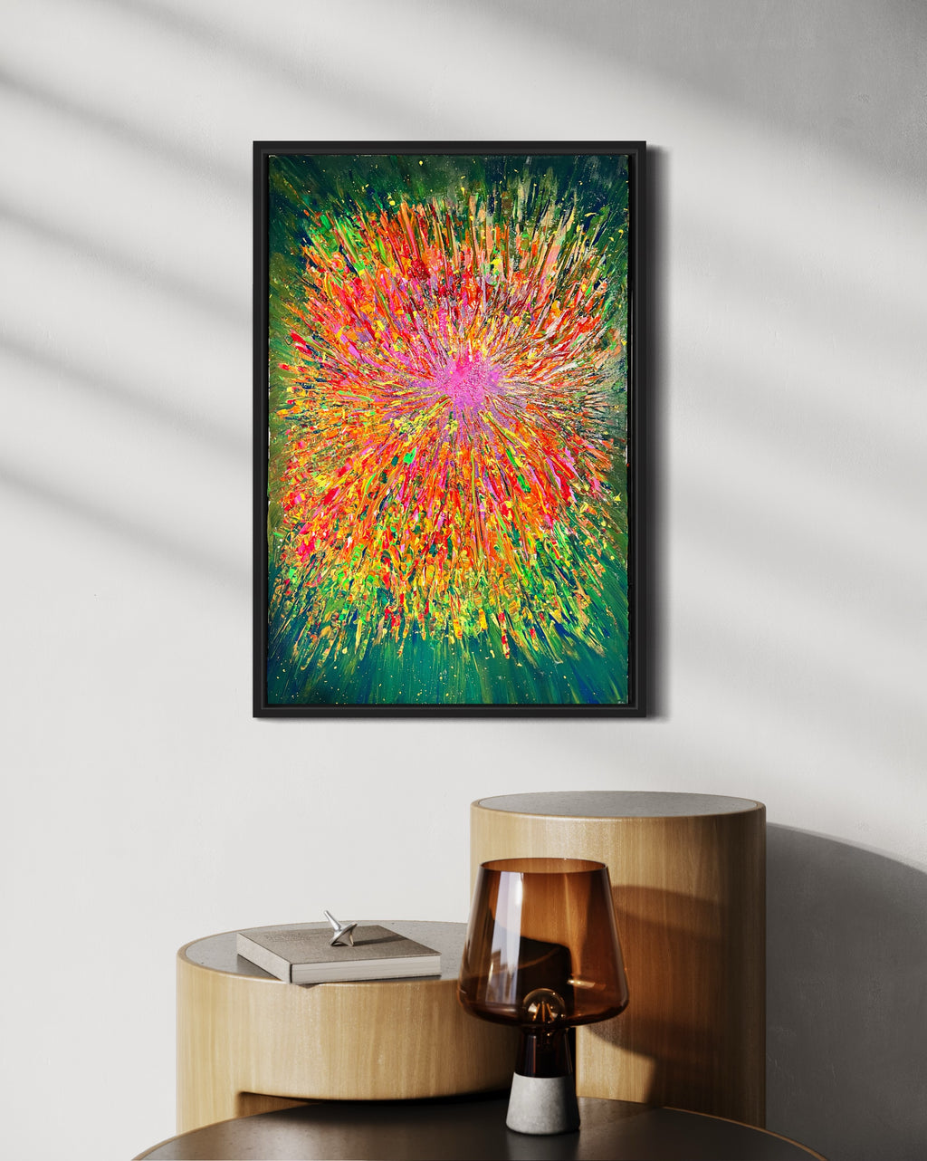 Framed abstract artwork showing a radiant color burst with green, orange, and pink streaks.