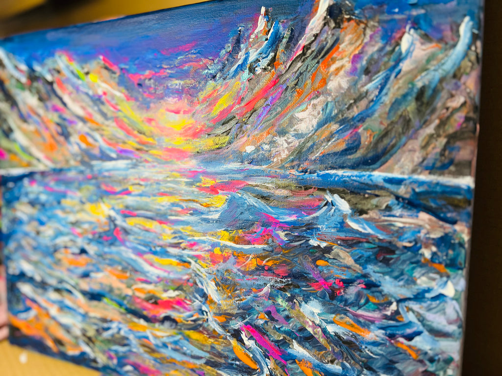Abstract canvas painting with blue, orange, and pink layered brushstrokes on a diagonal view