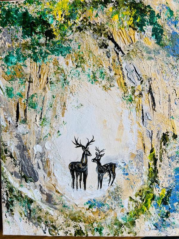 Canvas wall art with two deer silhouettes in the middle of a forest-style scene