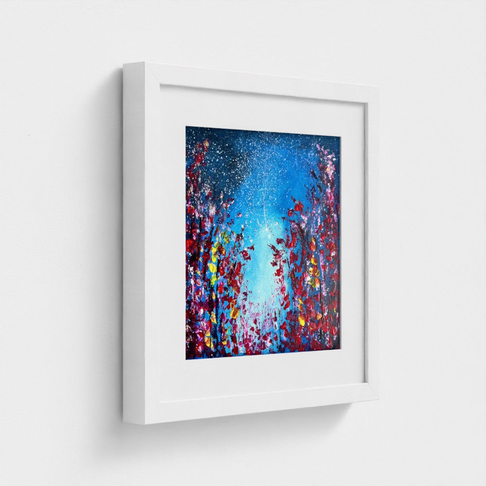 Framed fine art print with blue abstract paint splatter and starry speckles; white frame.