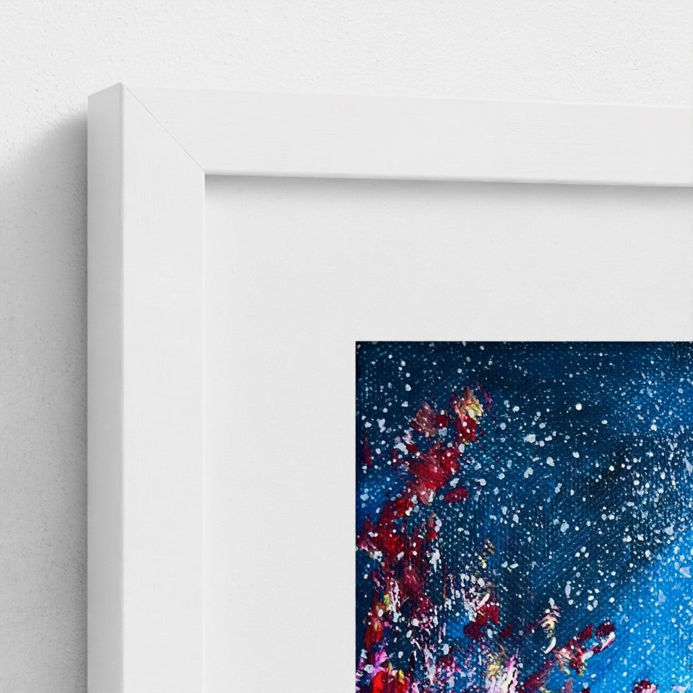 Framed wall art corner showing white mat and blue abstract speckled paint splashes.