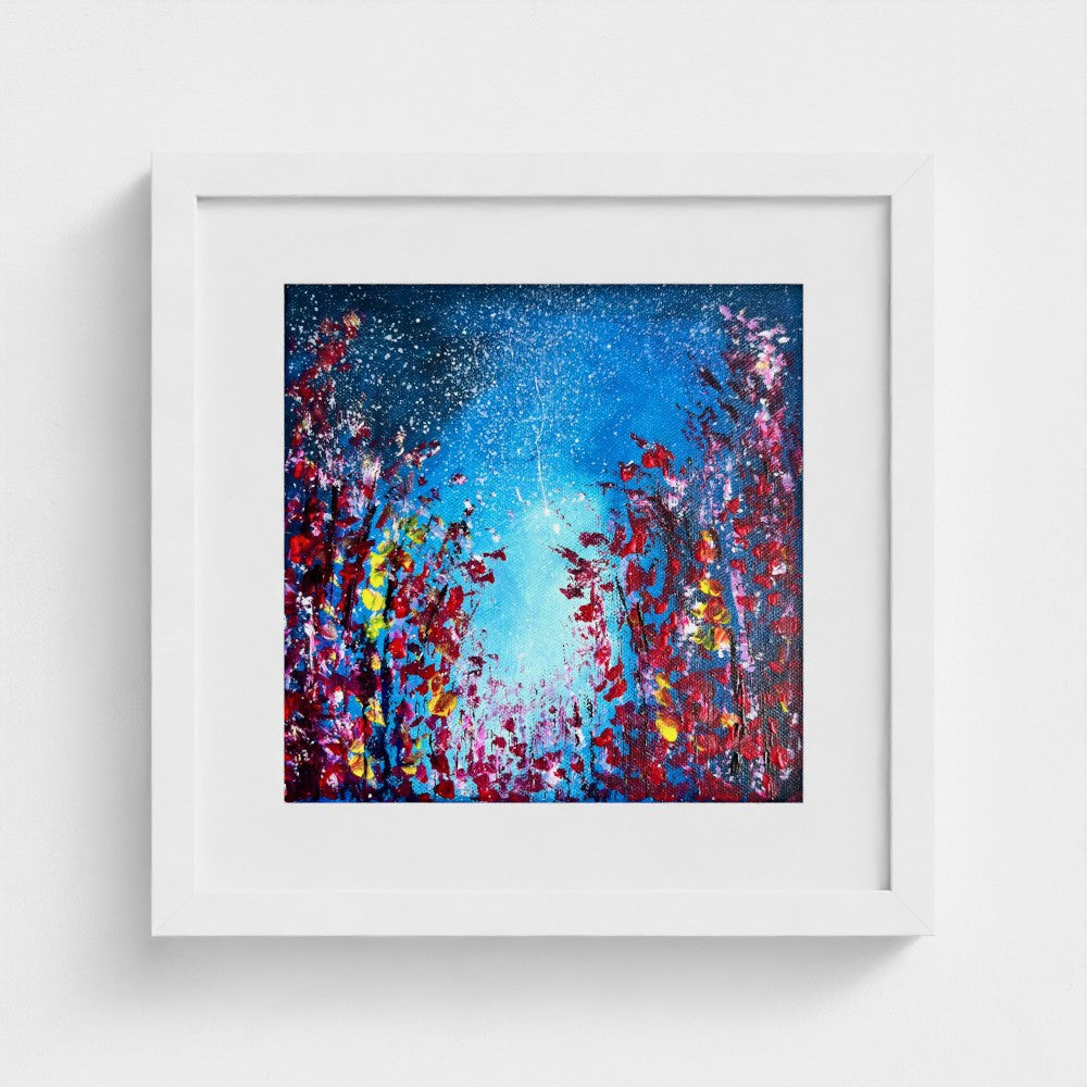 Framed fine art print with blue abstract paint splatter and bright white center; white frame.
