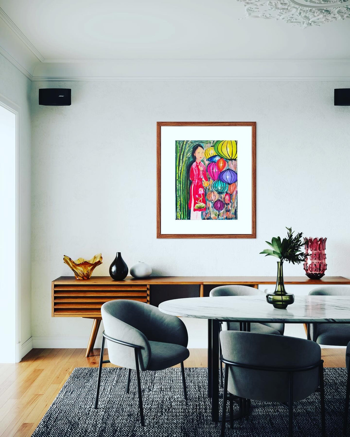 Framed acrylic on canvas painting of a Vietnamese woman in red with colorful lantern clusters