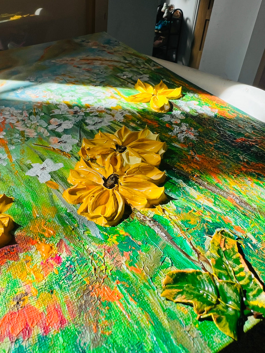 Wildflower canvas detail with two yellow blossoms over green, orange, and white paint texture.