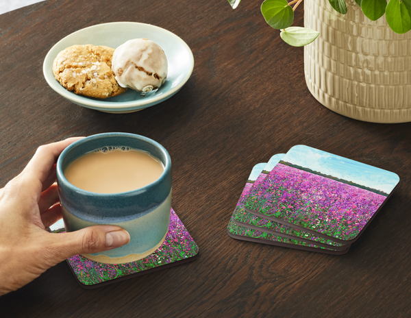 Square coaster with purple wildflower field print; teal ceramic mug in use